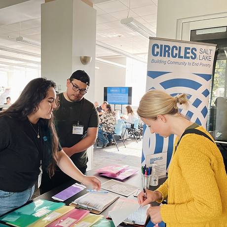 volunteers helping check a woman in to an event